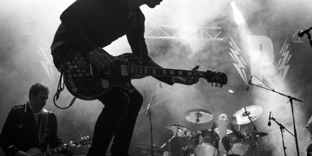 man playing a guitar on a concert